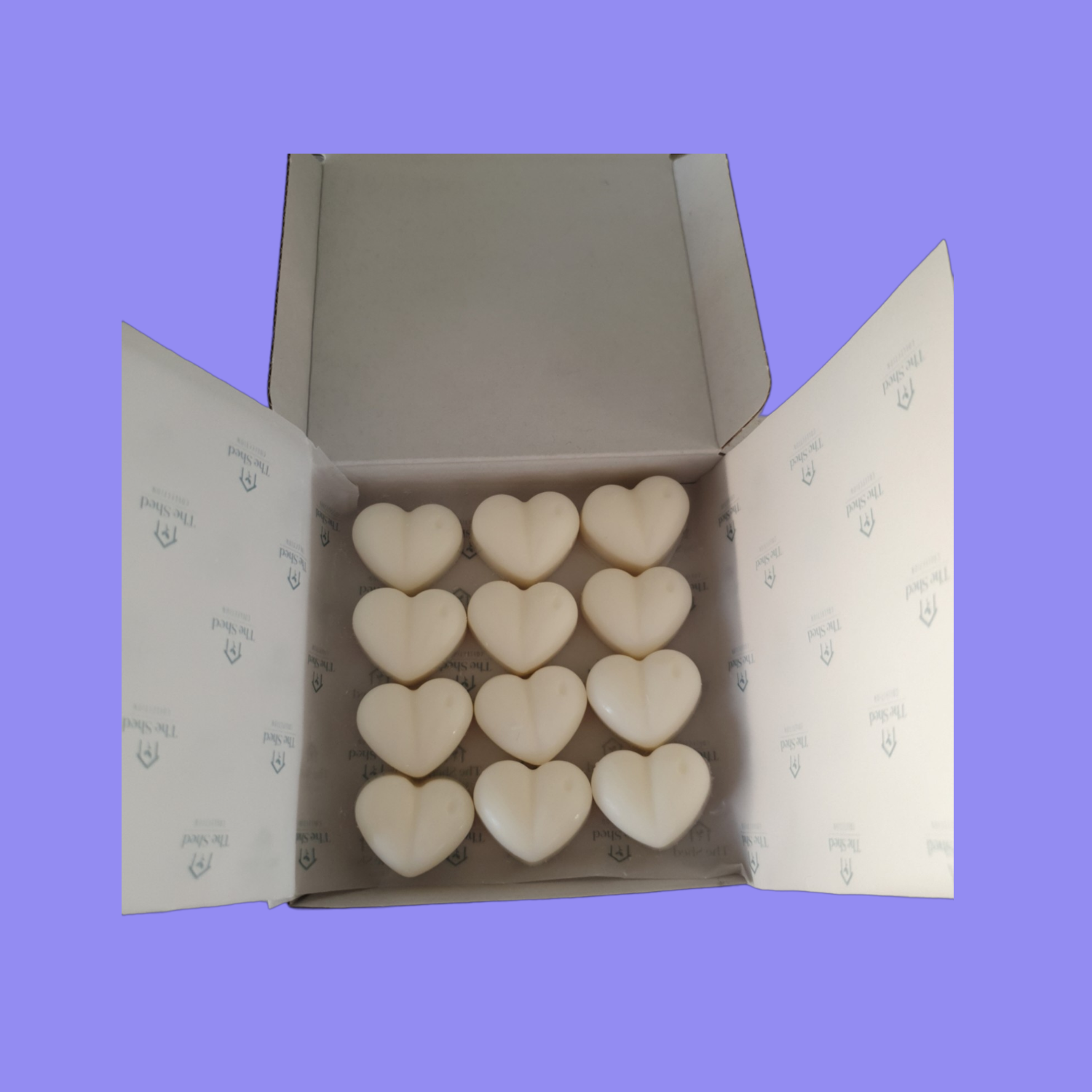 A box of 12  heart-shaped wax melts on a light purple background