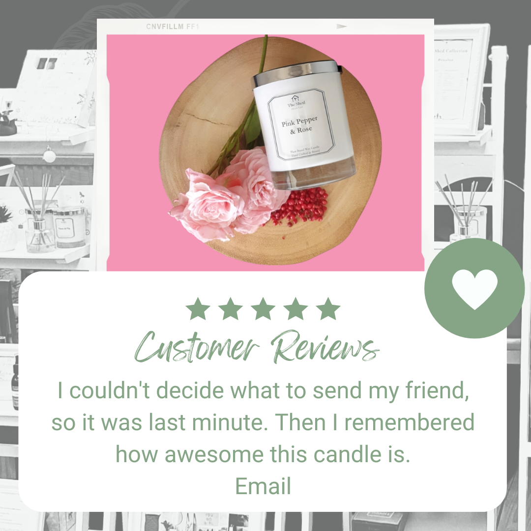 Candle on a wooden board with pink tea roses and pink peppercorns on a pink background. The text is a 5 star customer review.