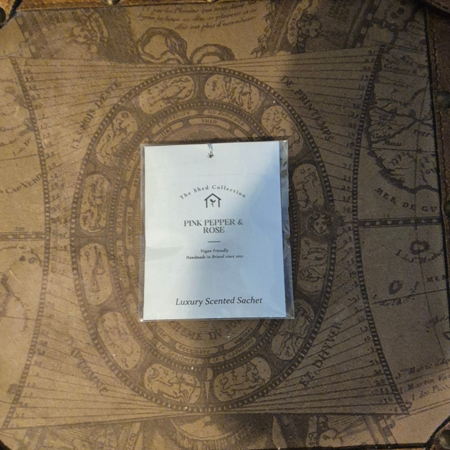 Scented sachet packaging on an ornate map background
