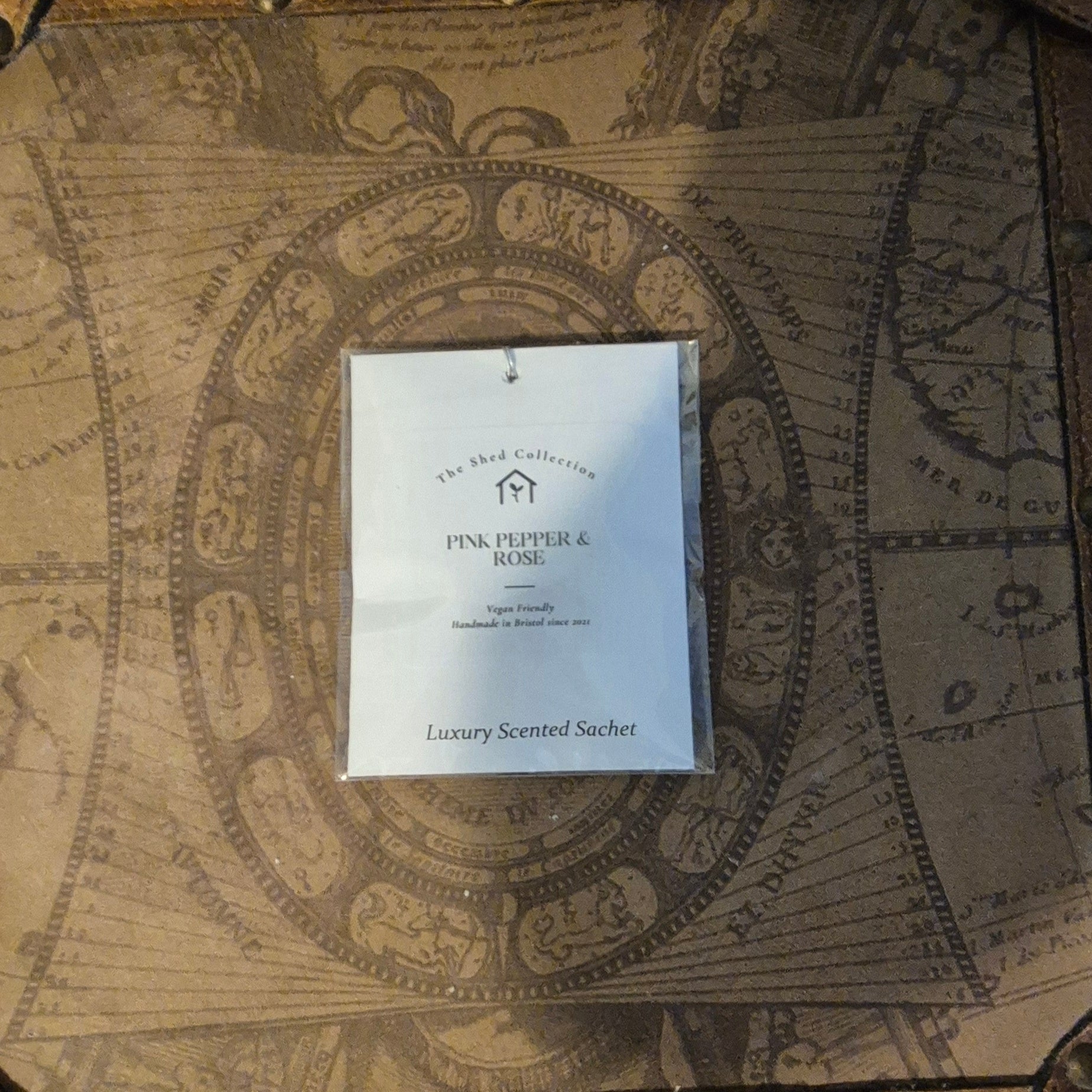 Scented sachet packaging on an ornate map background